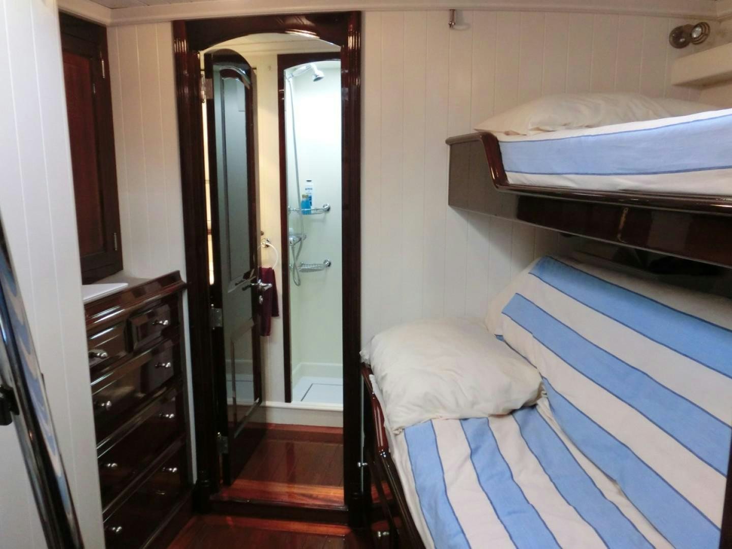 a bedroom with a bed and a dresser aboard CARMELLA  Yacht for Sale