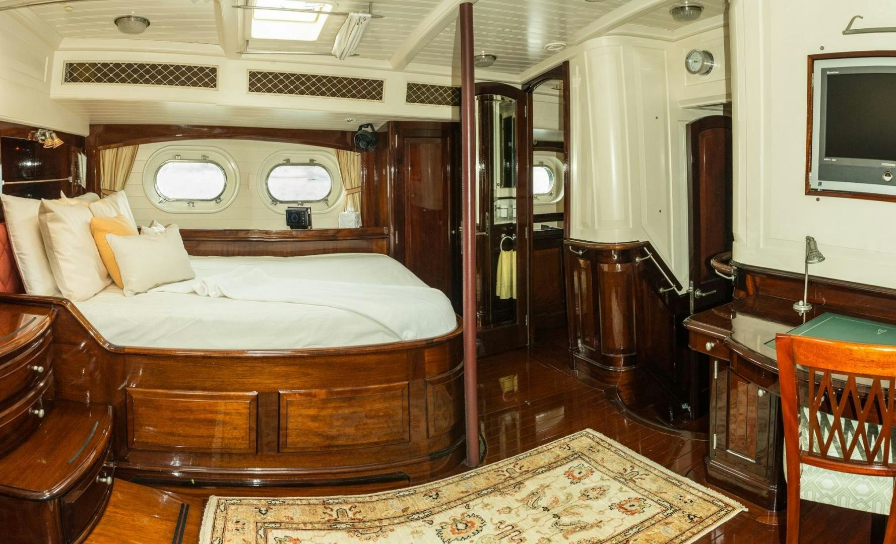 a bedroom with a bed and a television aboard CARMELLA  Yacht for Sale