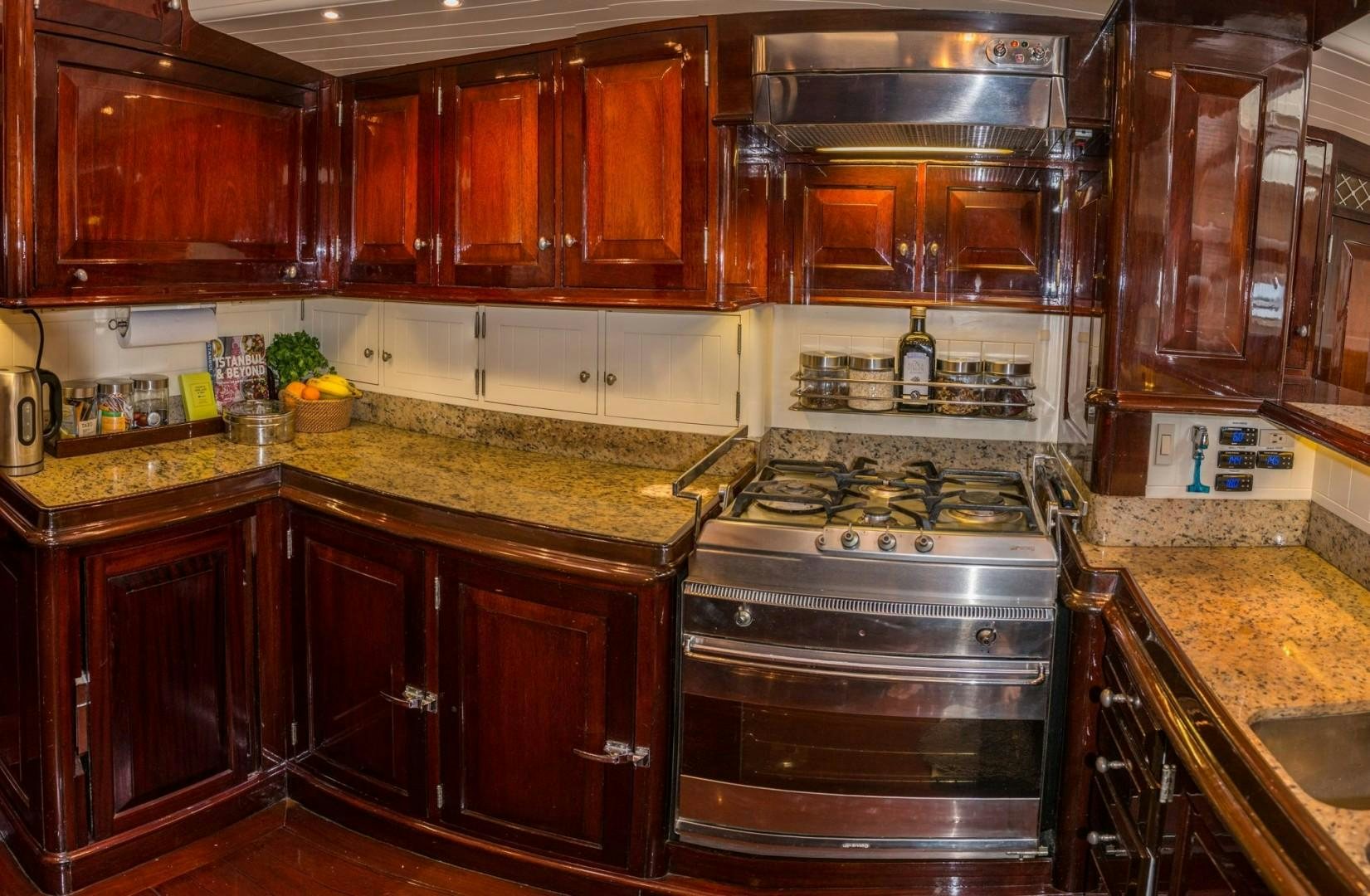 a kitchen with wooden cabinets aboard CARMELLA  Yacht for Sale