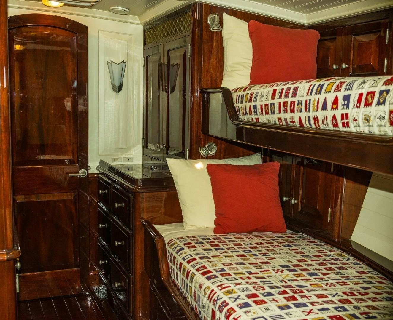 a bedroom with a bed and a dresser aboard CARMELLA  Yacht for Sale
