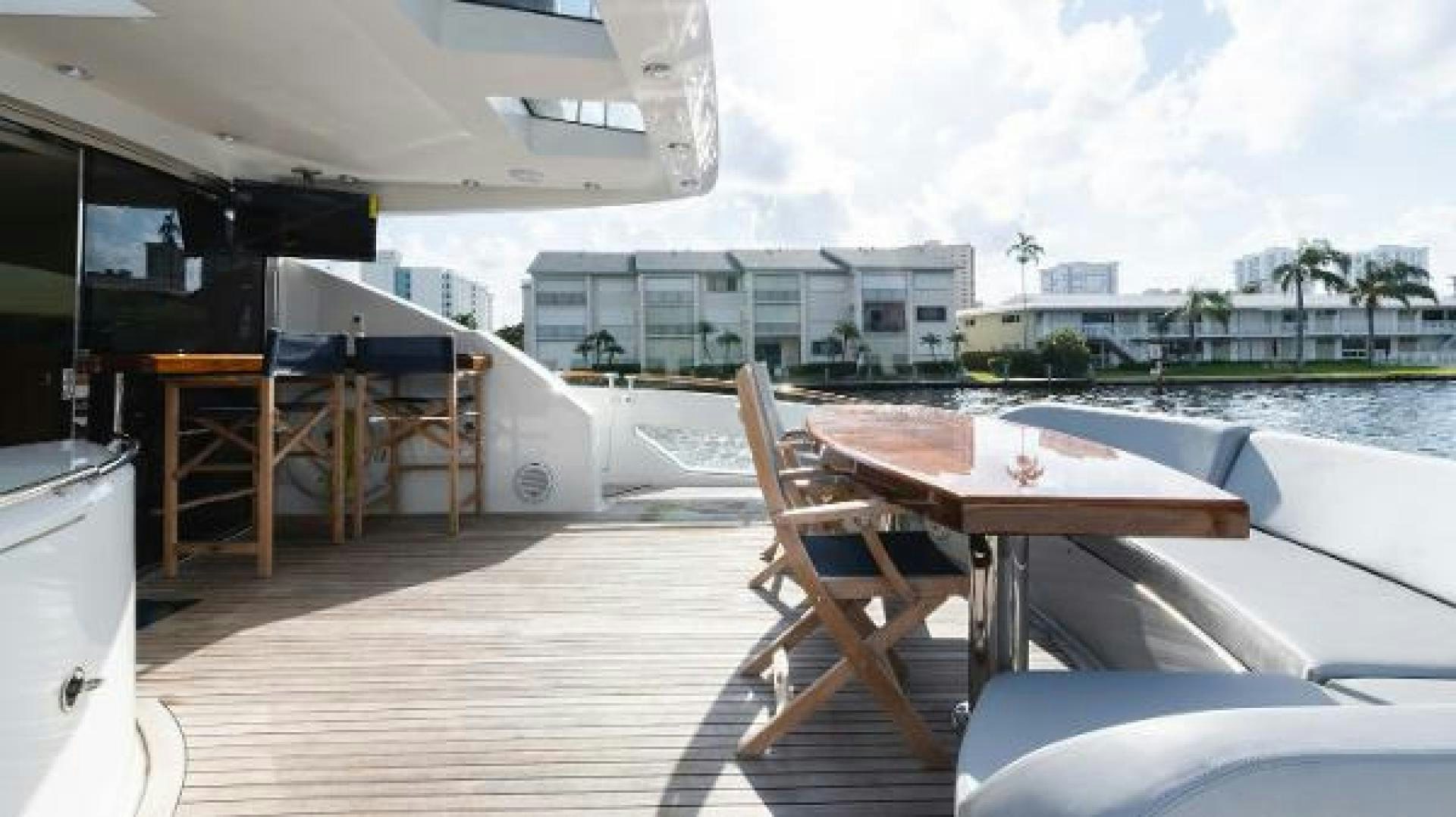 a deck with a table and chairs on it aboard Z Yacht for Sale