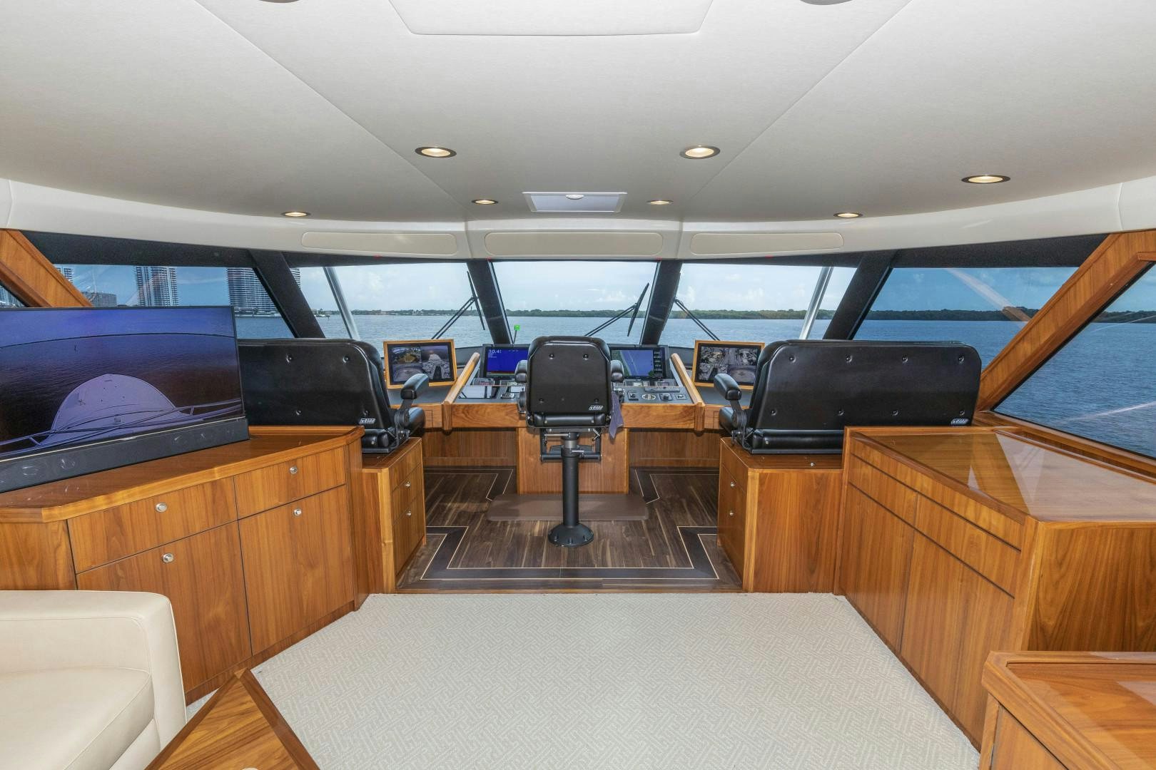 inside of a vehicle with a large screen and a table and chairs aboard BELLA DONA DI Yacht for Sale