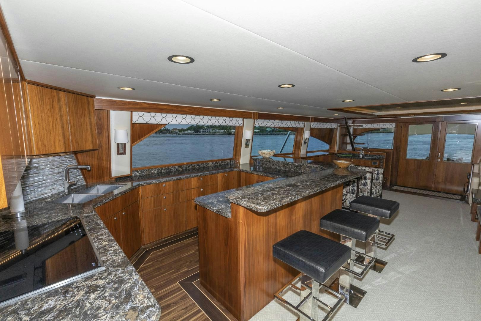 a large kitchen with a bar and bar stools aboard BELLA DONA DI Yacht for Sale