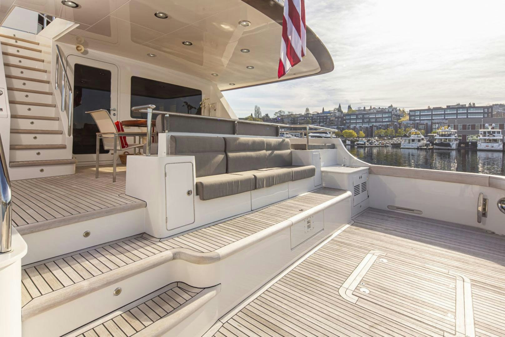 a deck with a large white sofa and a flag on the roof aboard PARAGON COCKPIT Yacht for Sale