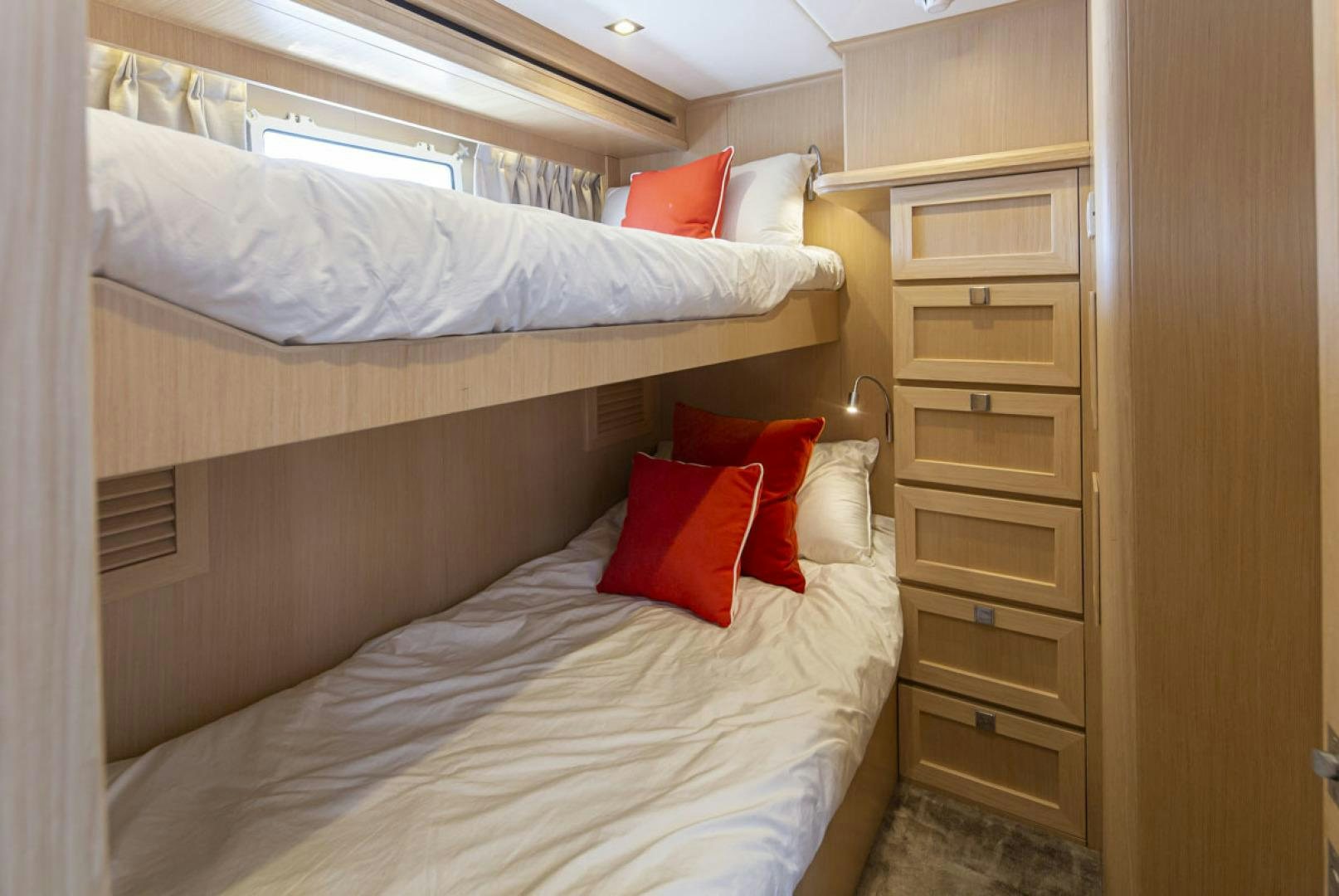 a bed with red pillows aboard PARAGON COCKPIT Yacht for Sale