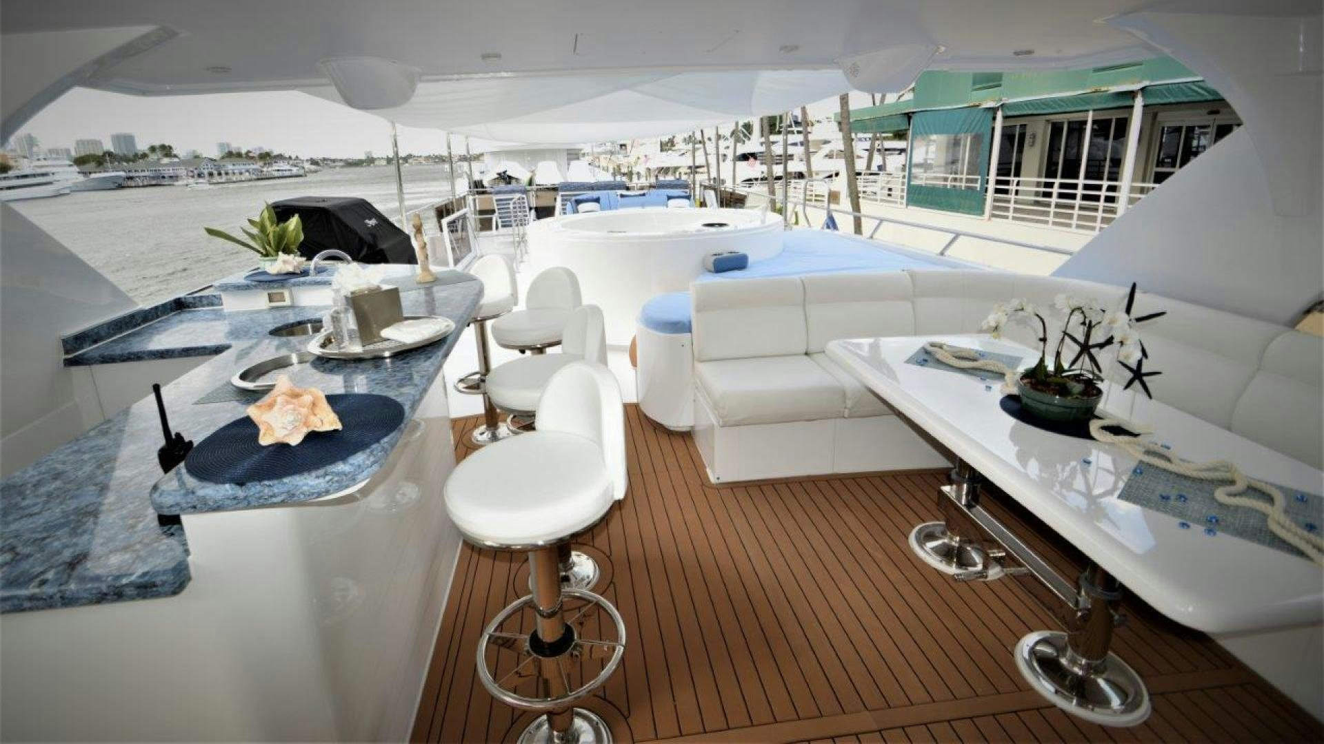 a room with a table chairs and a large white building with a view of the city aboard NO NAME Yacht for Sale
