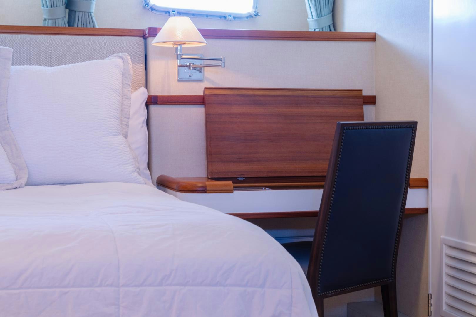 a bed with a chair and a desk in a room aboard NORDIC STAR Yacht for Sale