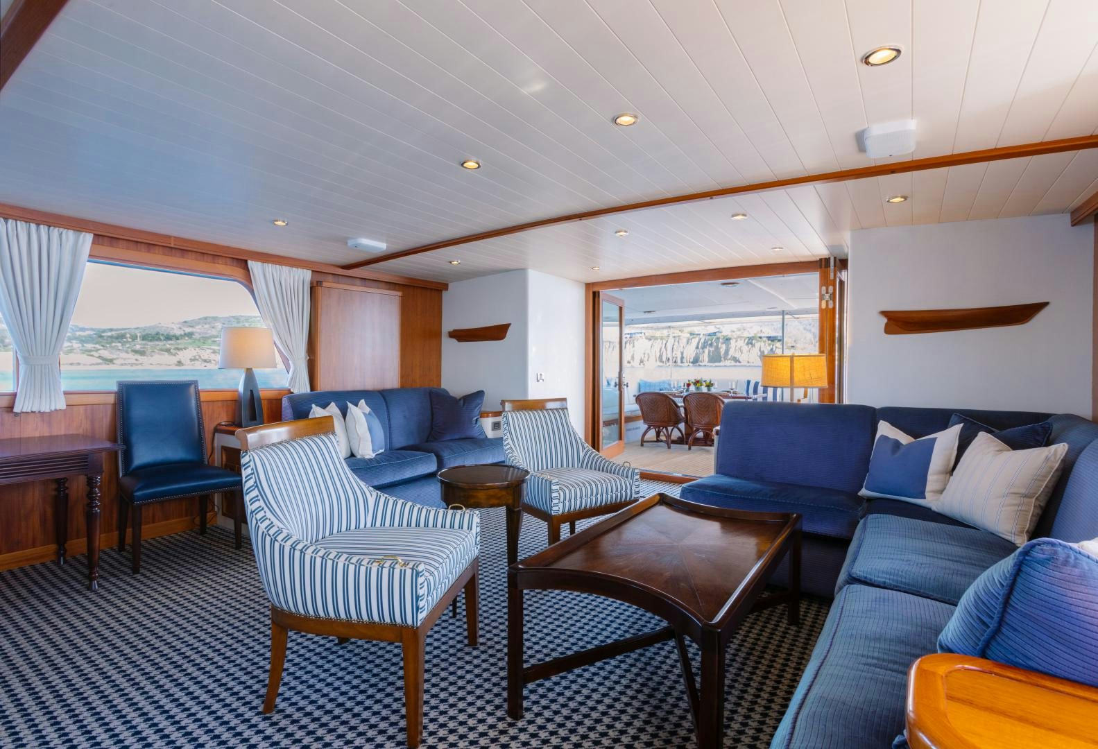 a large living room with a blue couch and a large window aboard NORDIC STAR Yacht for Sale
