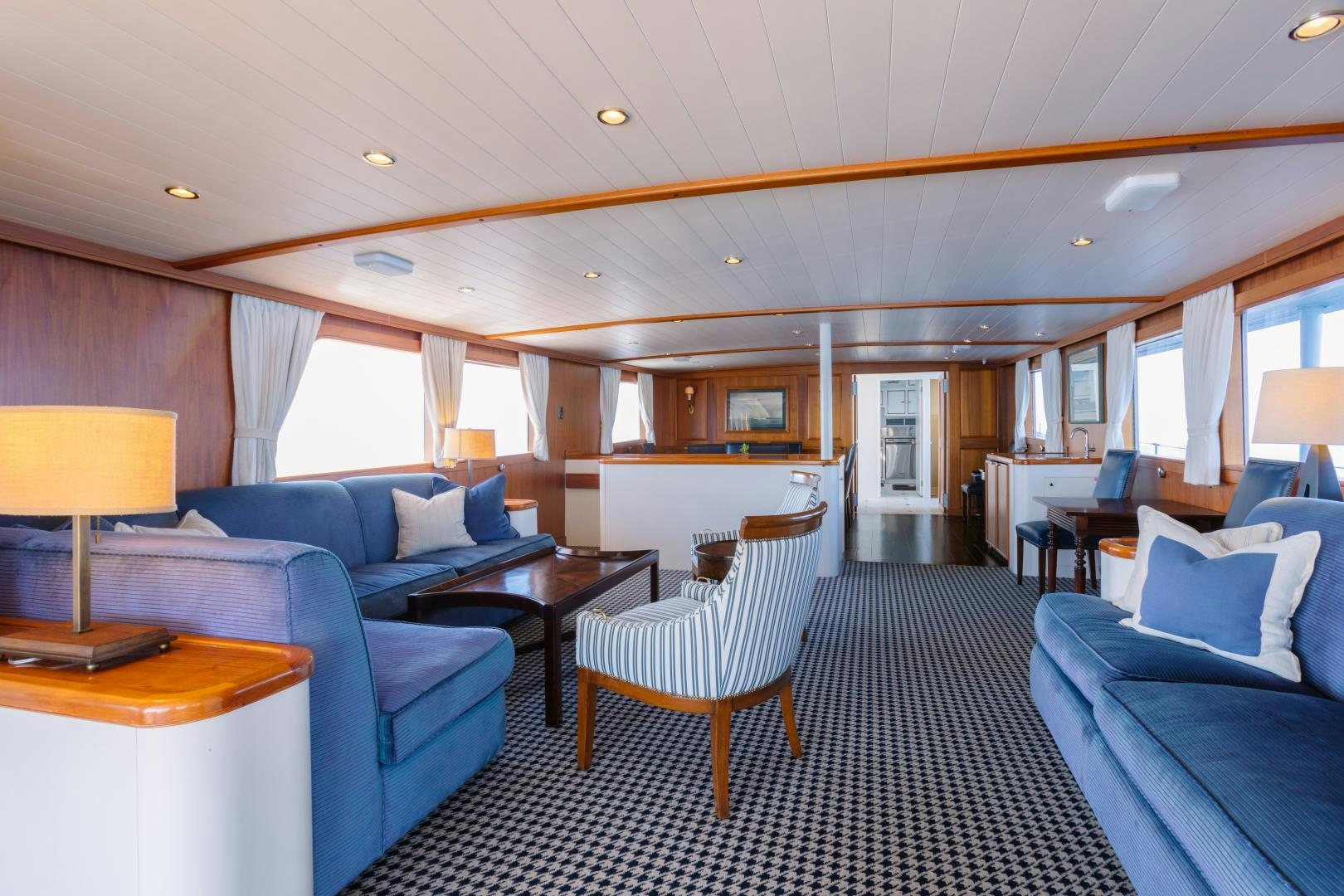 a large living room with a blue couch and a table aboard NORDIC STAR Yacht for Sale
