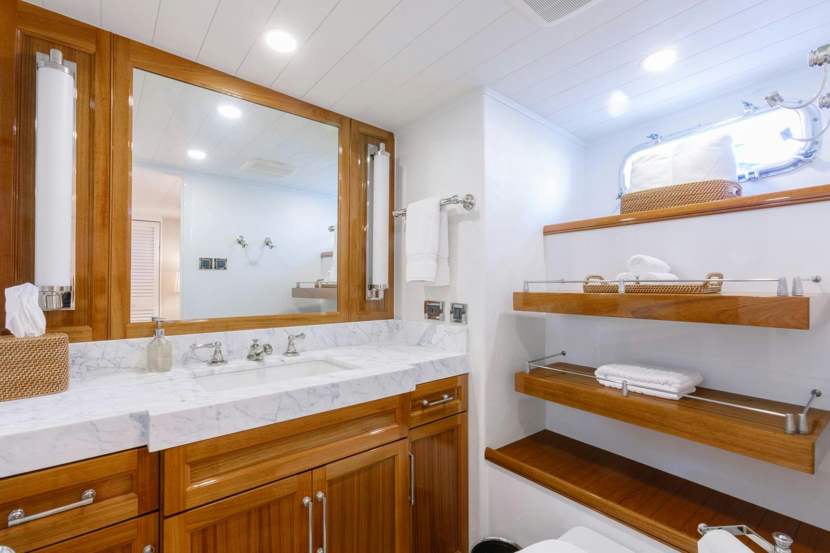 a bathroom with a mirror and a shelf with towels on it aboard NORDIC STAR Yacht for Sale