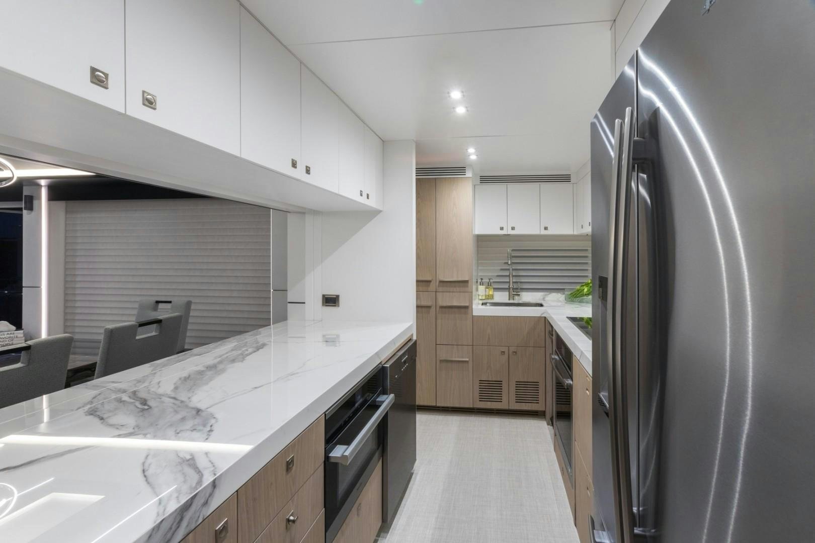 a kitchen with a fridge and a table aboard No Name Yacht for Sale