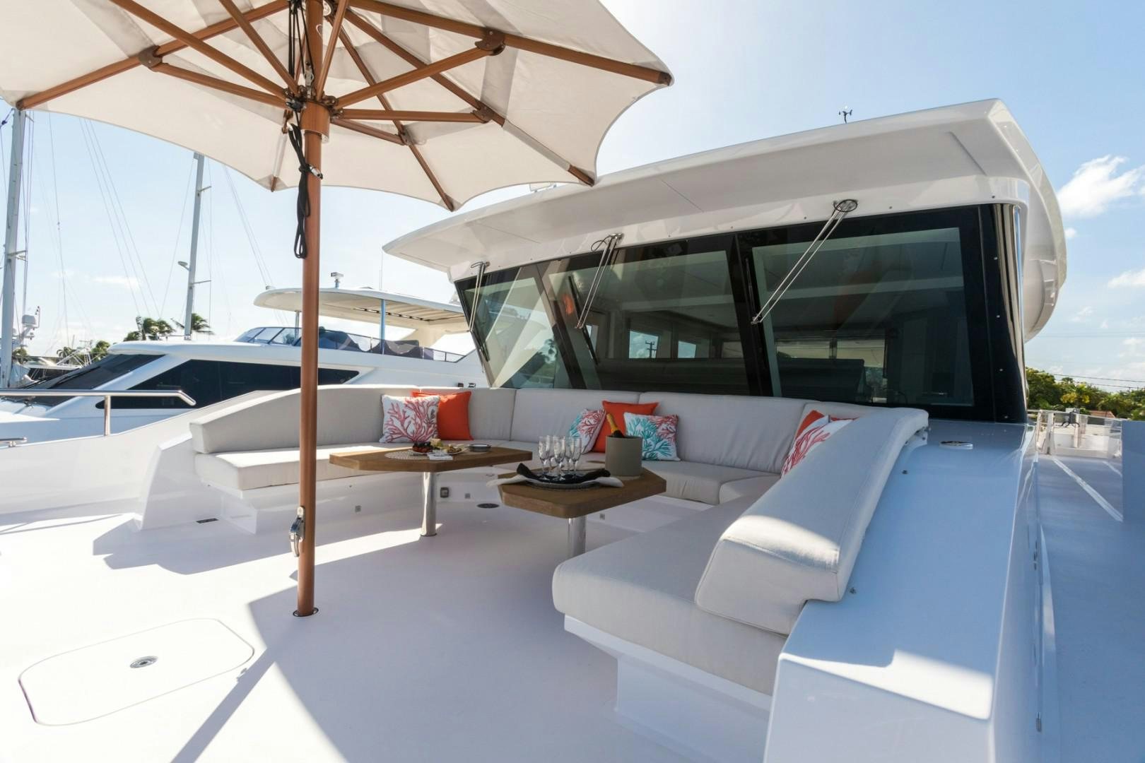 a lounge area with a lounge chair and umbrella aboard No Name Yacht for Sale
