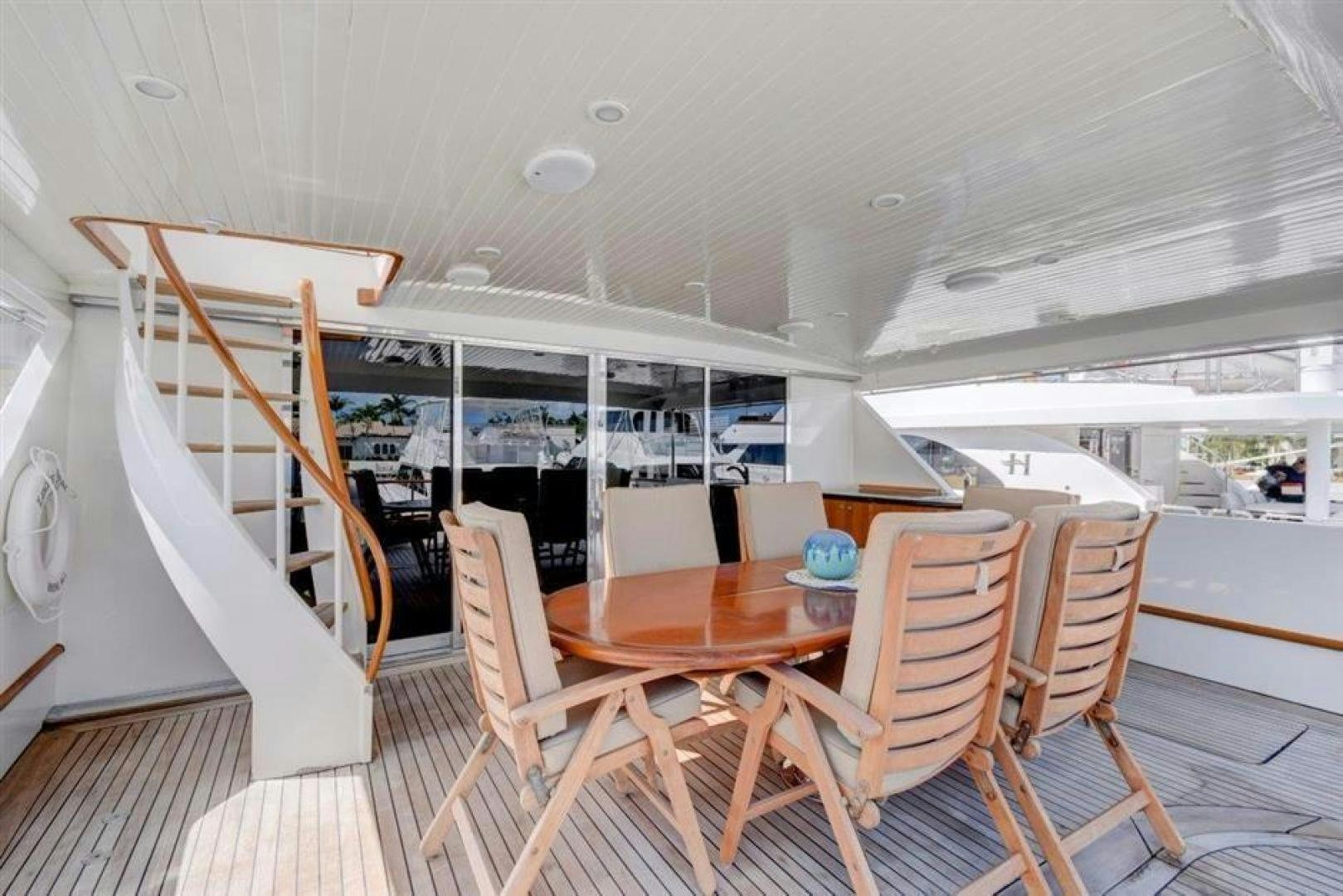 a room with a table chairs and a ladder aboard LUCKY STAR Yacht for Sale