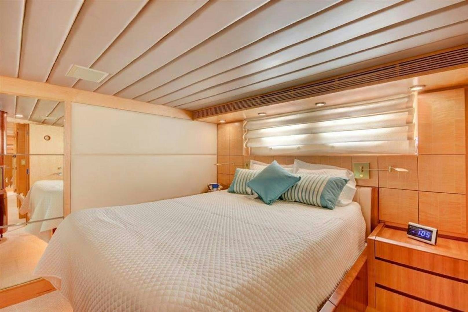 a bed with a white sheet and blue and white pillows aboard LUCKY STAR Yacht for Sale