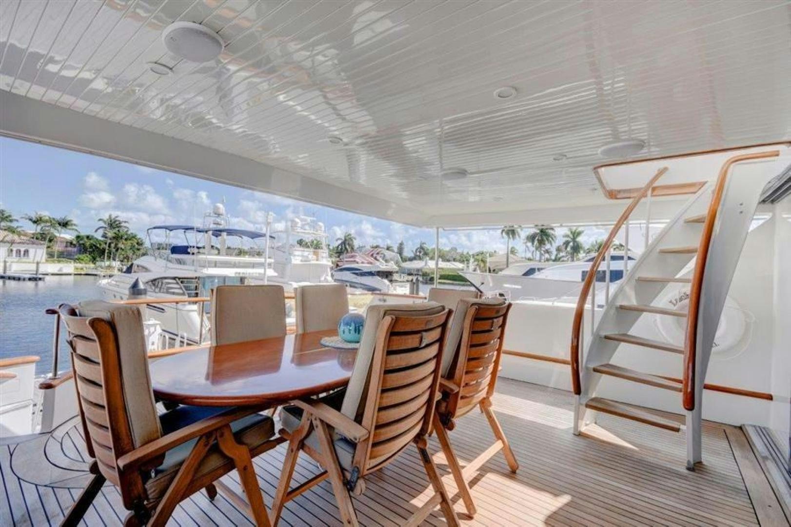 a deck with a table and chairs aboard LUCKY STAR Yacht for Sale