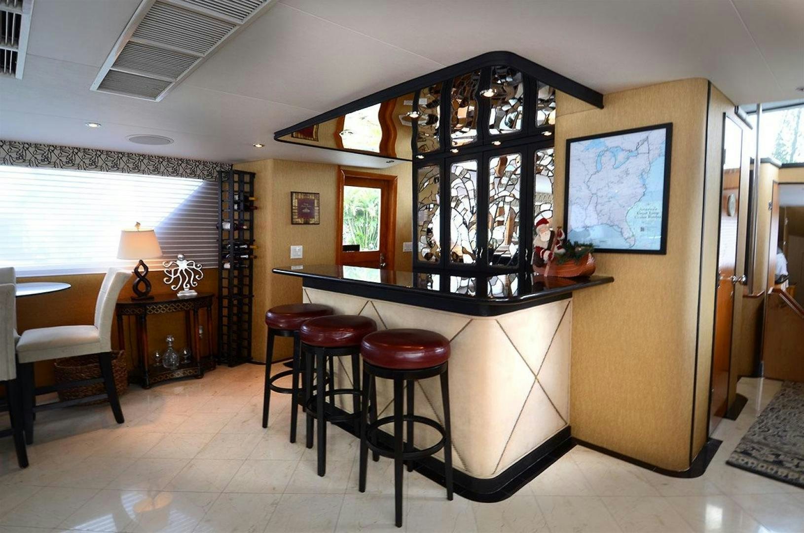 a room with a bar stools and a table and chairs aboard GOLDEN GIRL Yacht for Sale