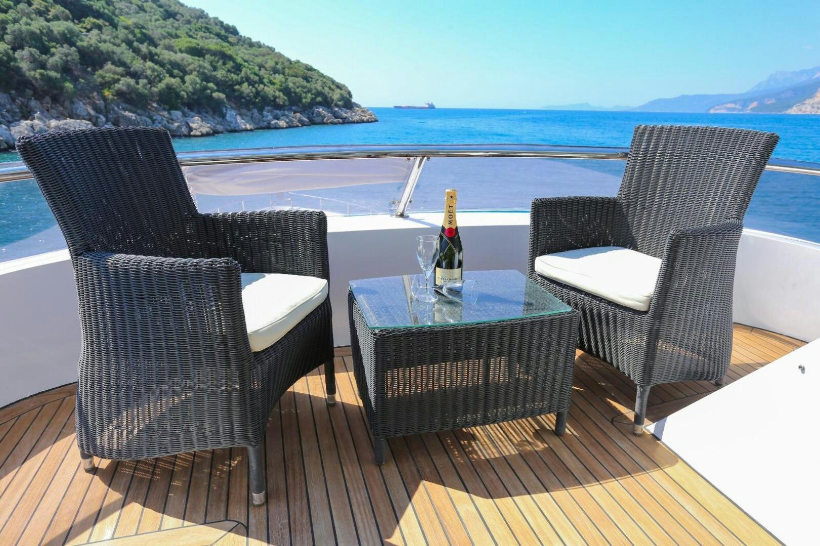 a table and chairs on a deck overlooking a body of water aboard NO NAME Yacht for Sale