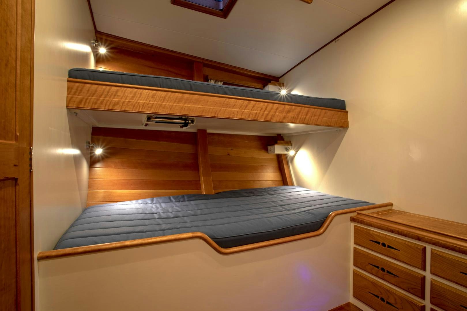 a bed with a blue sheet aboard SONNY III Yacht for Sale