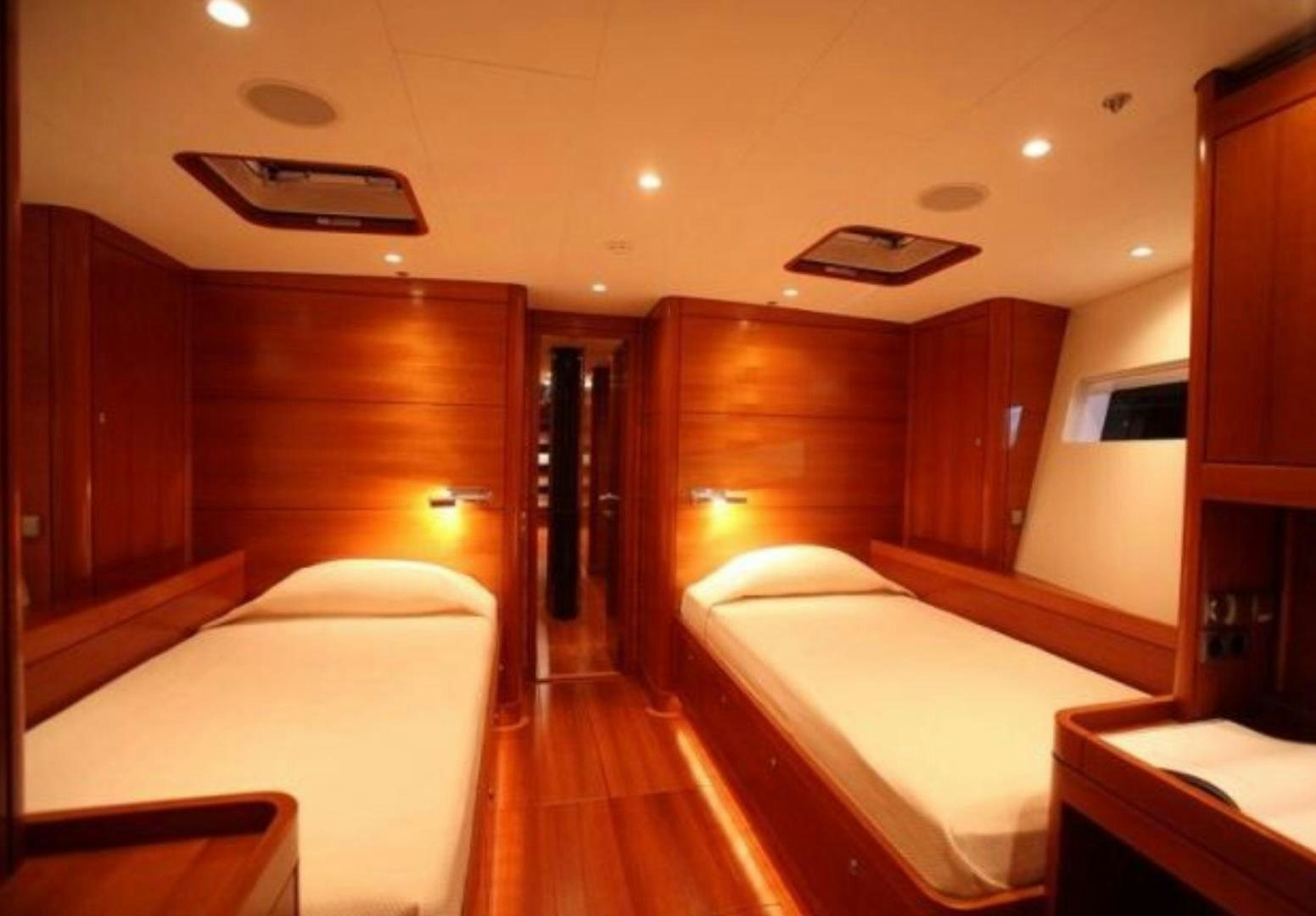 a room with a bed and a wood wall aboard B5 Yacht for Sale