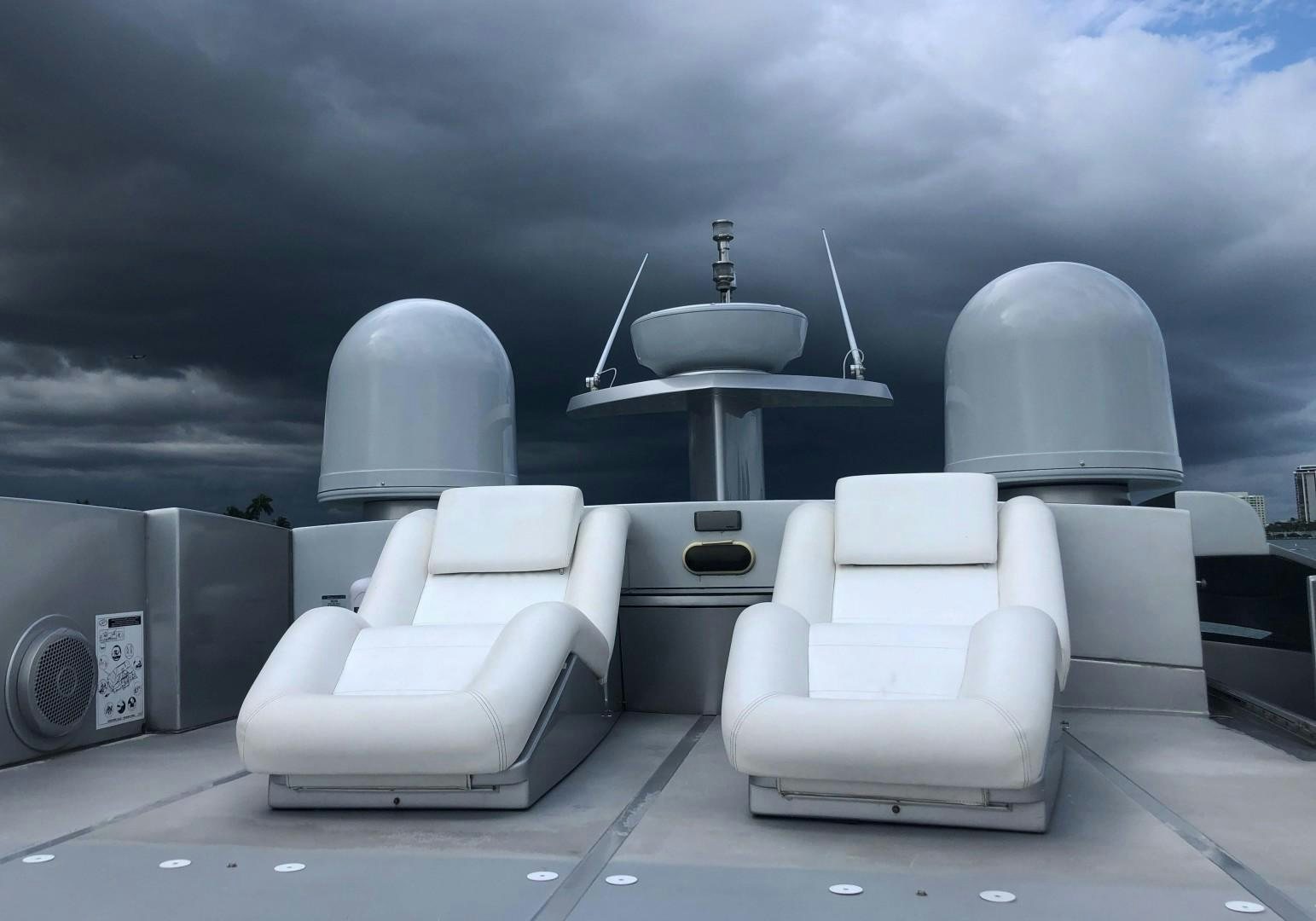 a group of white chairs in front of a large black wall aboard YCM 90 Yacht for Sale