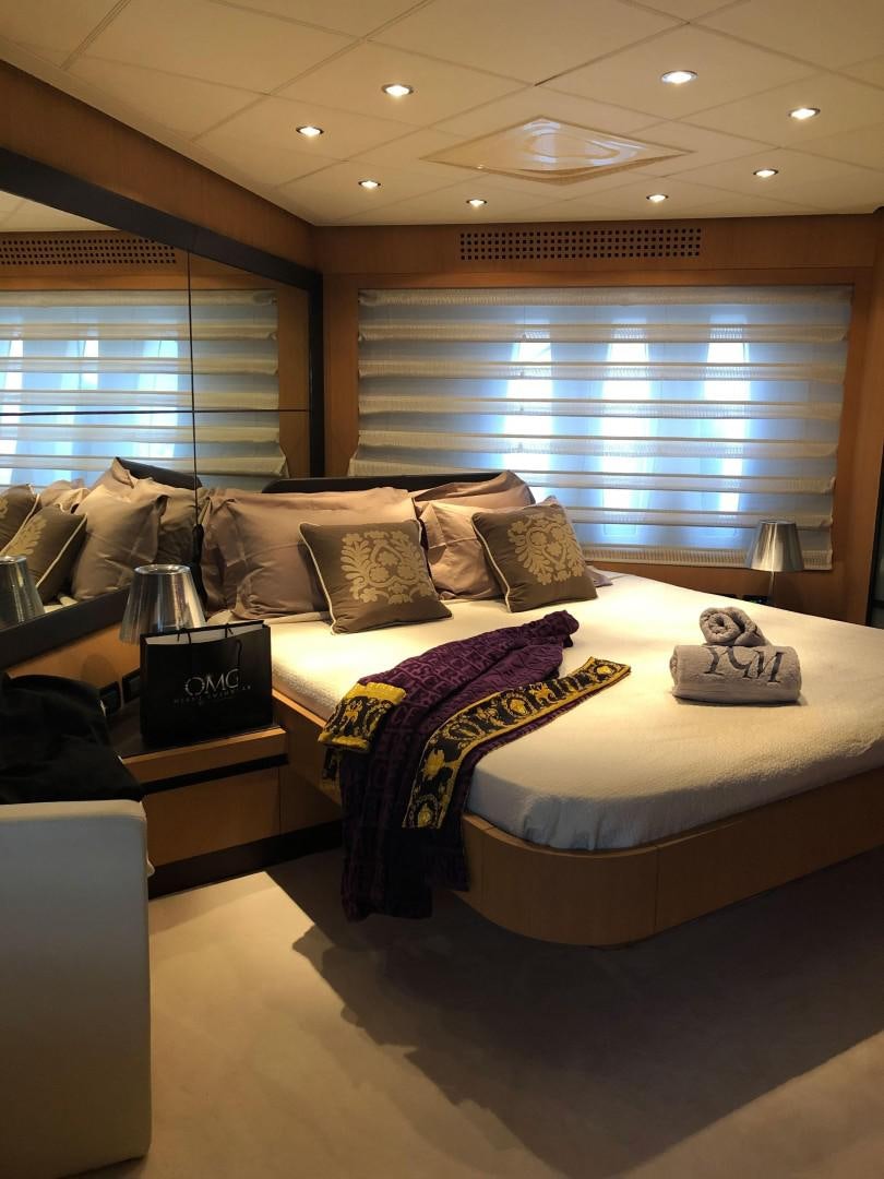 a bedroom with a bed and a desk aboard YCM 90 Yacht for Sale