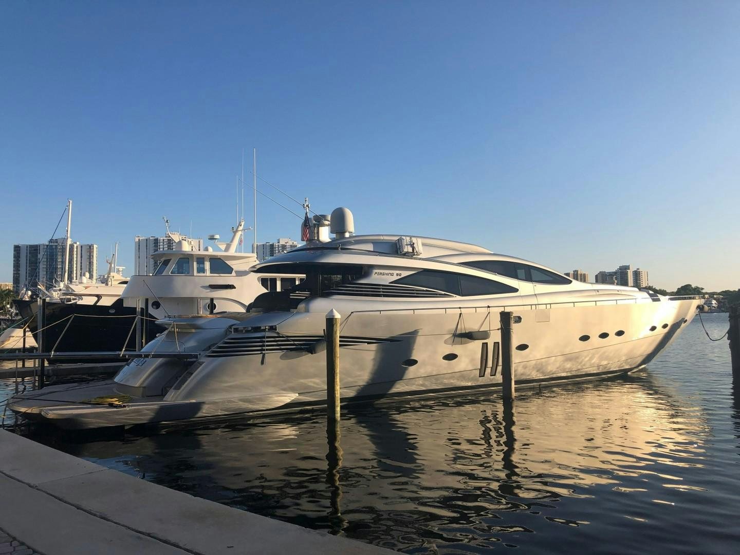 a white yacht docked at a dock aboard YCM 90 Yacht for Sale