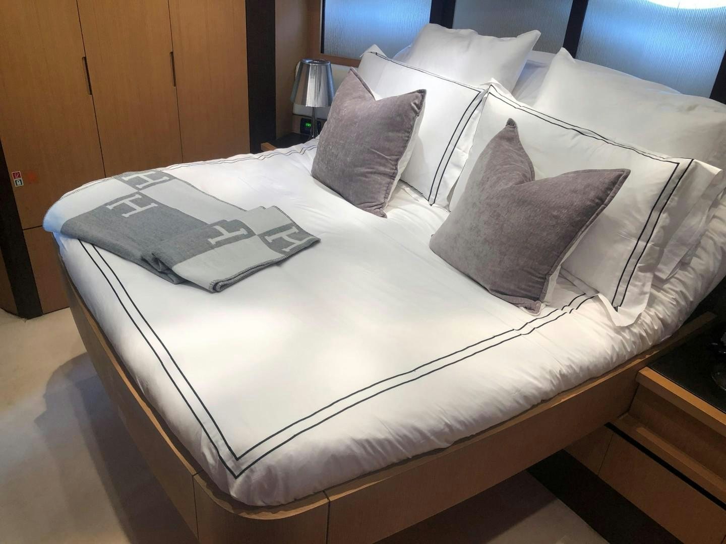 a bed with pillows and a book aboard YCM 90 Yacht for Sale