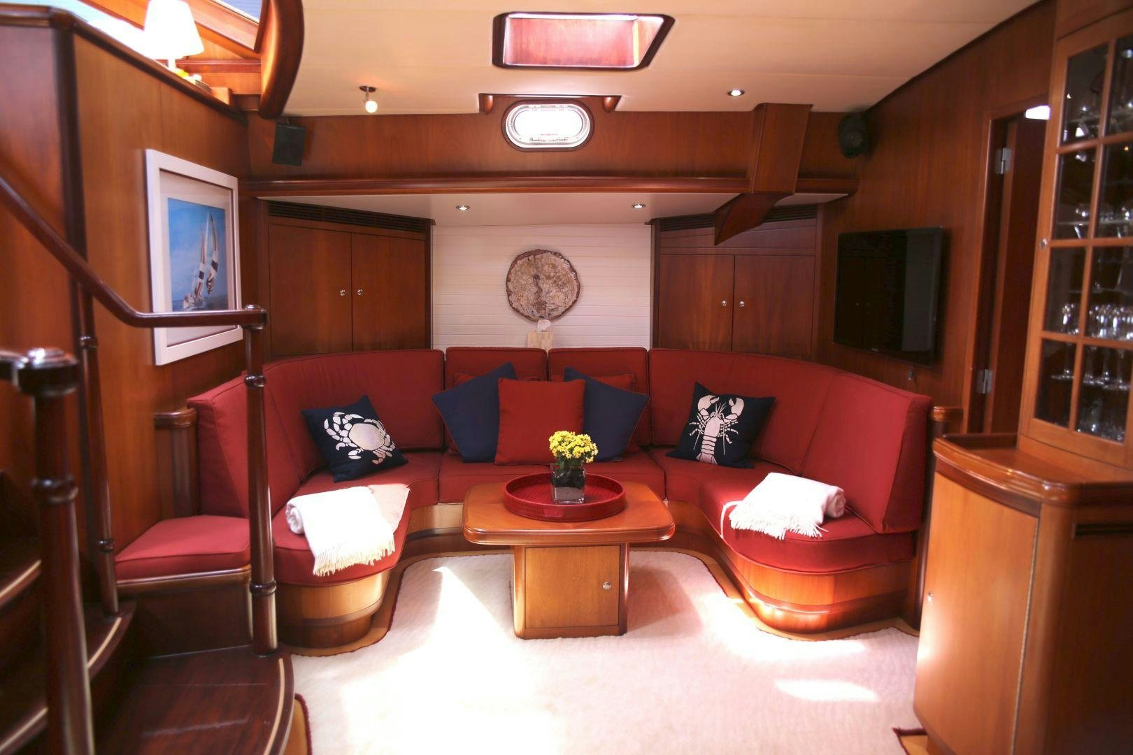 a living room with a red couch aboard WHIRLWIND Yacht for Sale