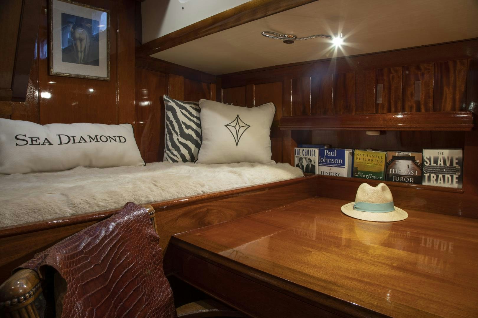 a bed with a table and a lamp on it aboard SEA DIAMOND Yacht for Sale