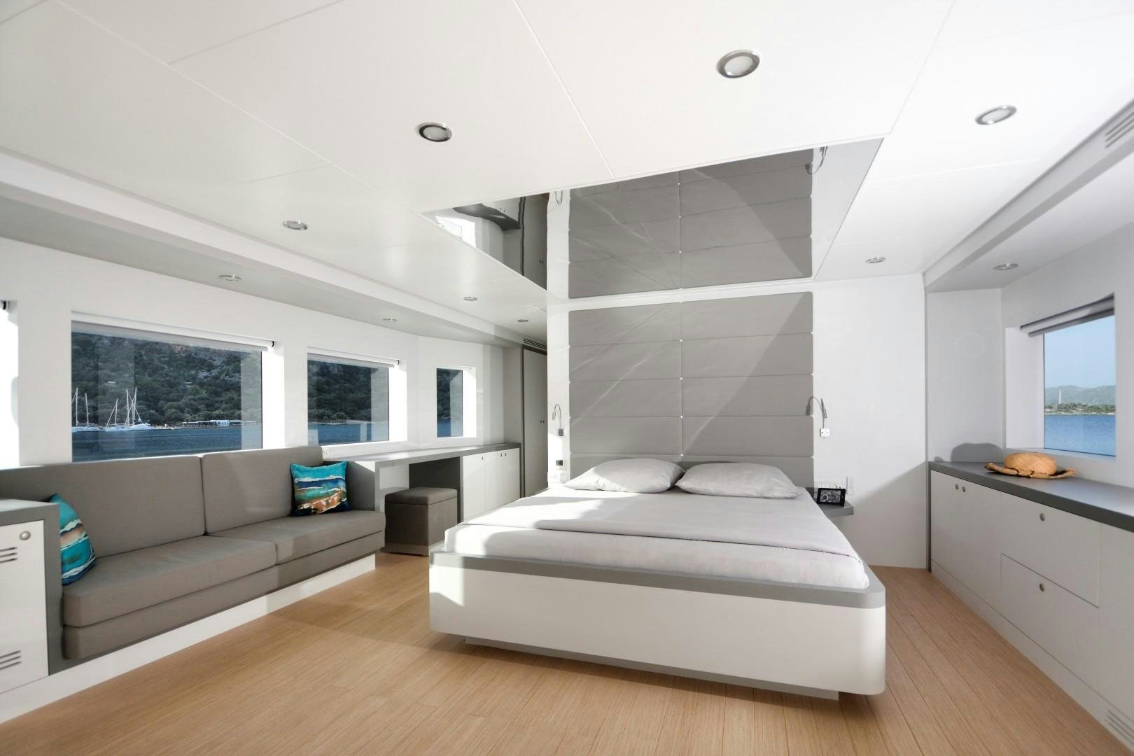 a bedroom with a bed and a couch aboard BIG JOY Yacht for Sale