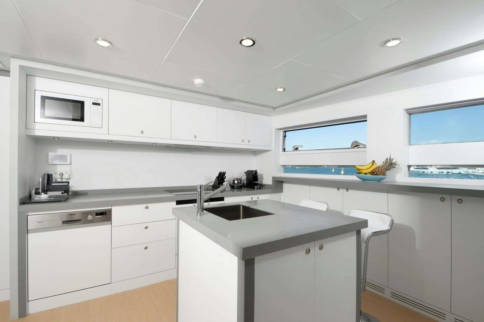 a kitchen with white cabinets aboard BIG JOY Yacht for Sale