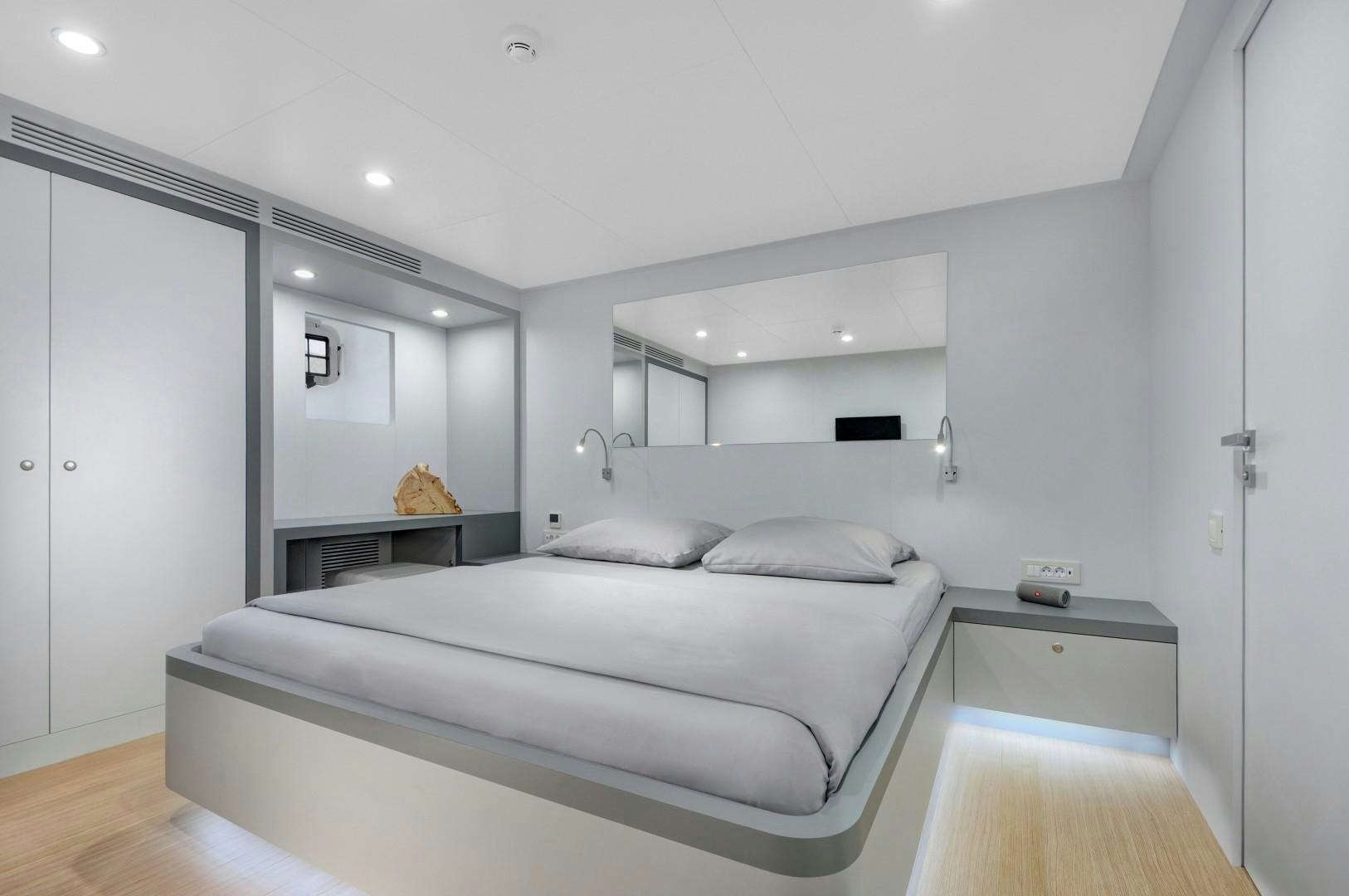 a white bedroom with a bed aboard BIG JOY Yacht for Sale