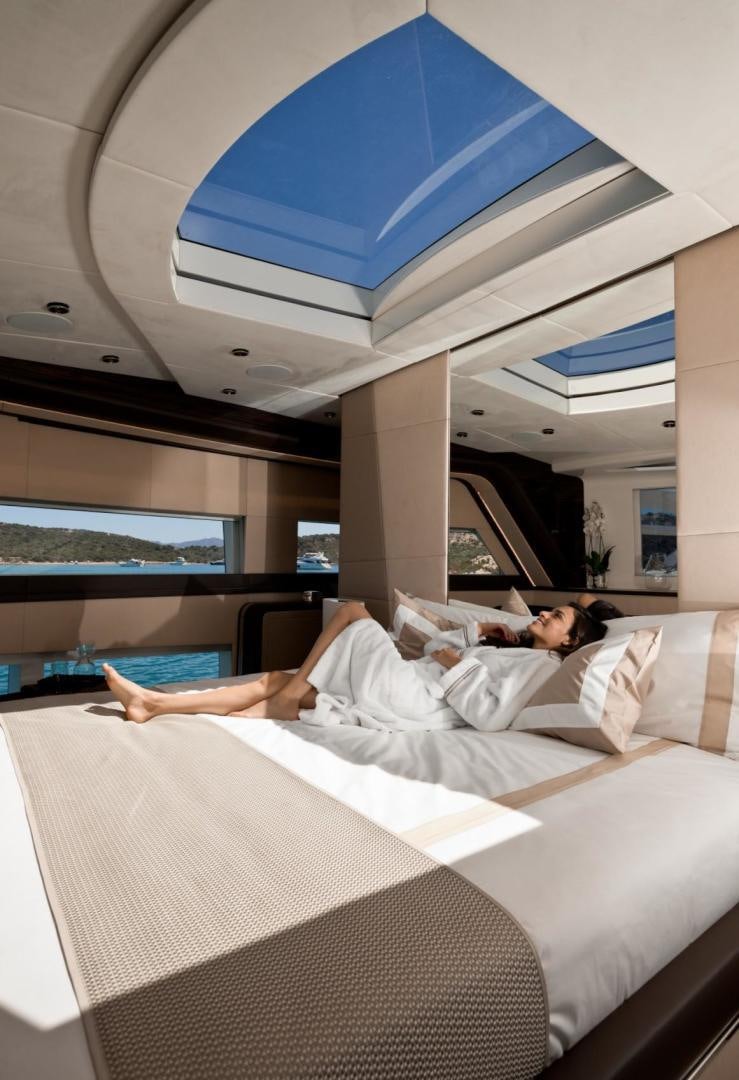 a couple of people lying on a bed aboard KALLIENTE Yacht for Sale