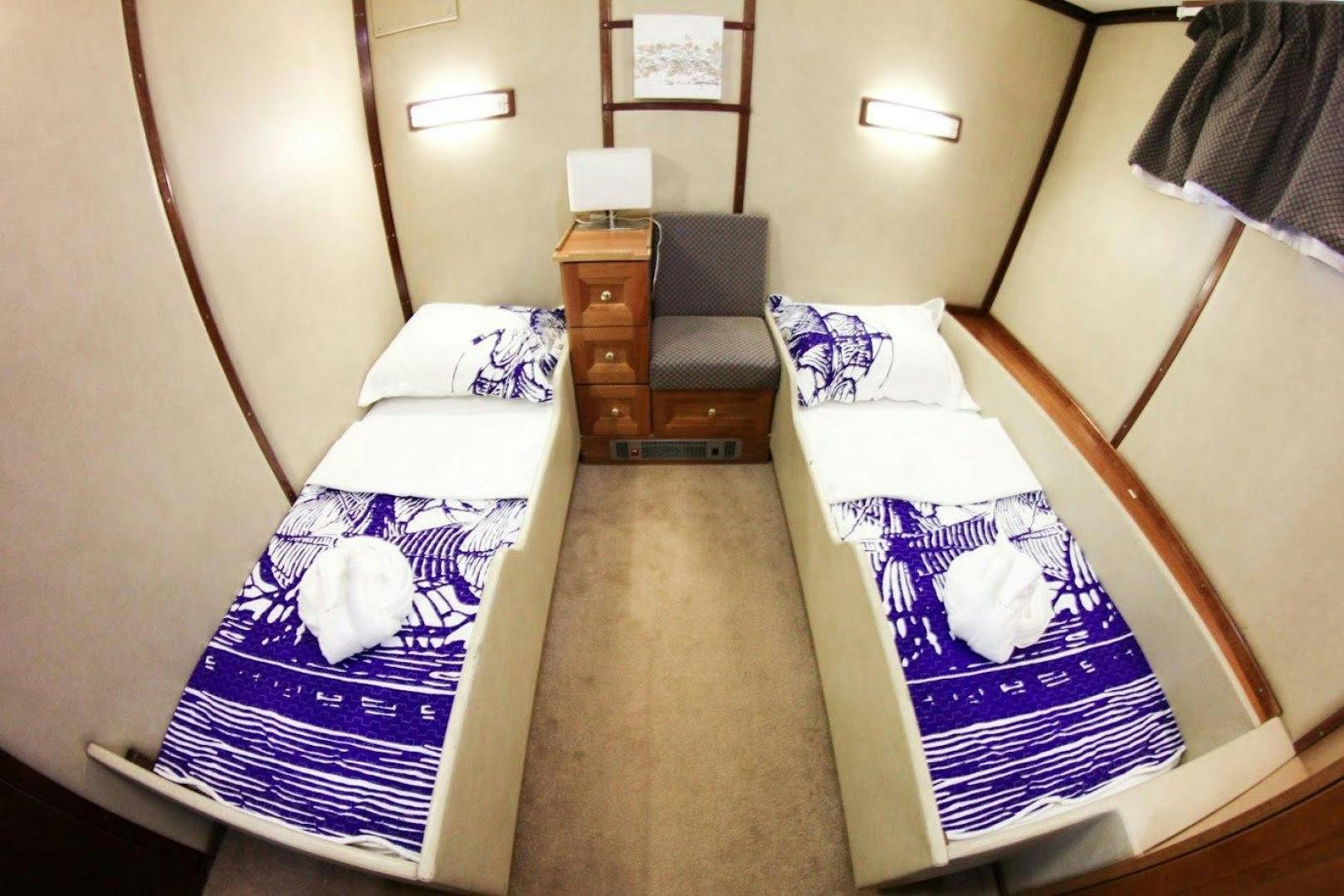 a room with a bed and a dresser aboard EVA Yacht for Sale