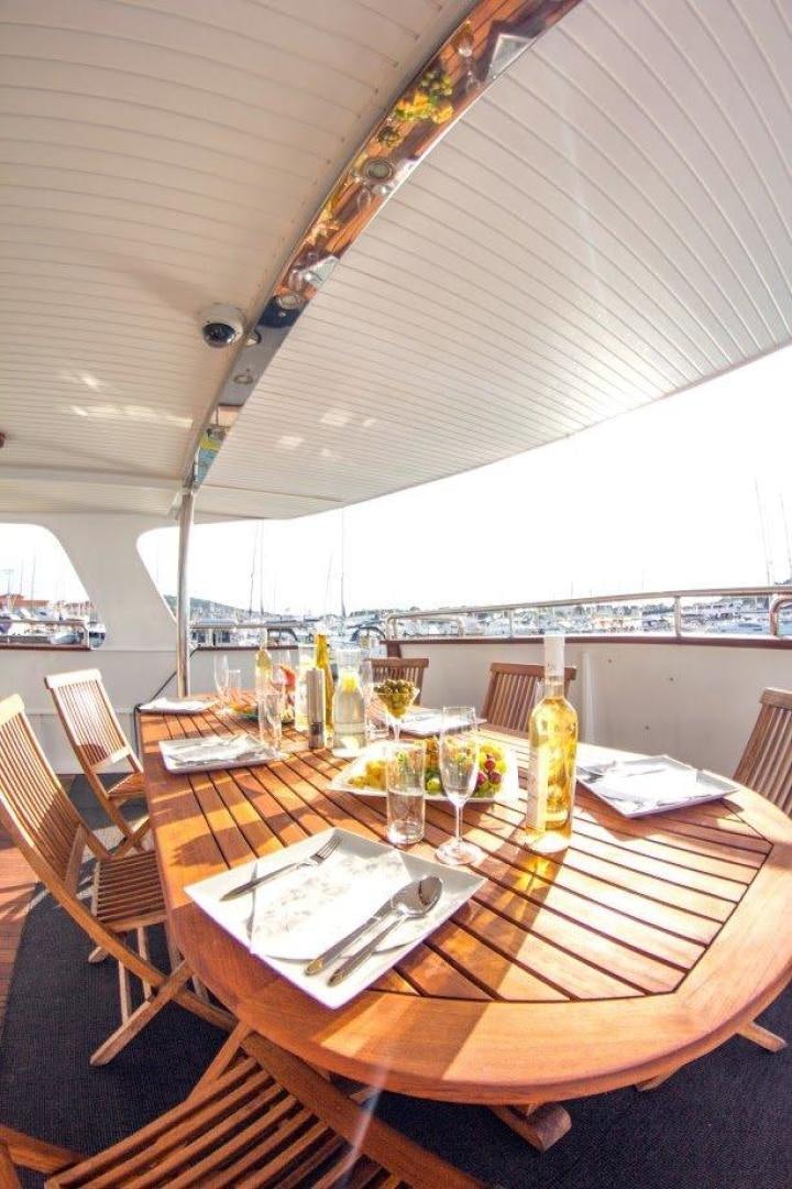 a table with wine glasses and plates on it aboard EVA Yacht for Sale