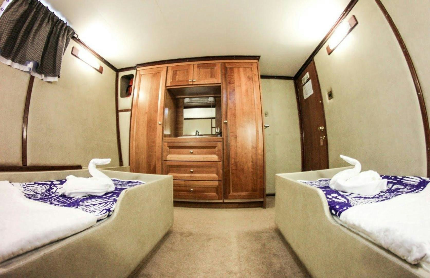 a room with a bed and a dresser aboard EVA Yacht for Sale