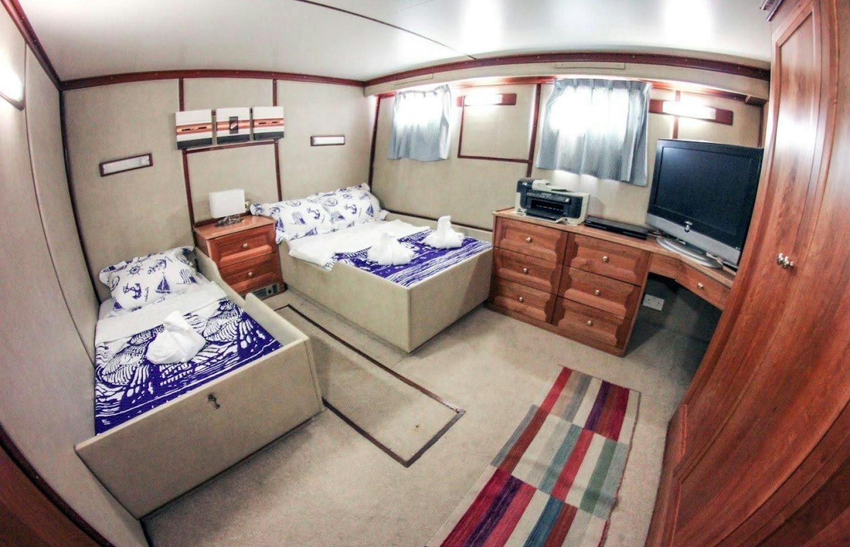 a bedroom with a bed and a tv aboard EVA Yacht for Sale