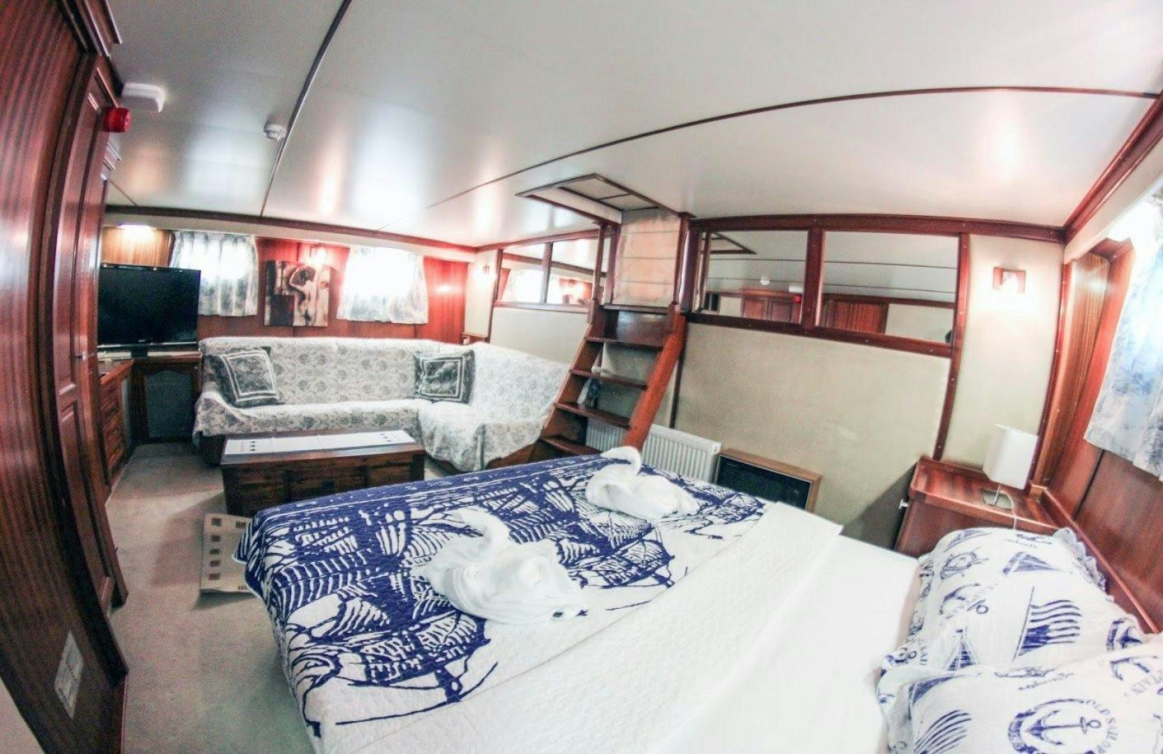 a room with a bed and a couch aboard EVA Yacht for Sale