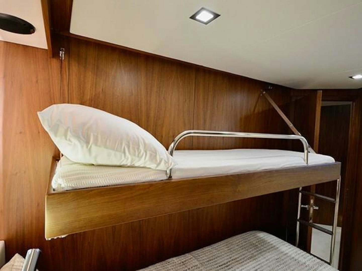 a bed with a white pillow aboard EXIMIUS Yacht for Sale