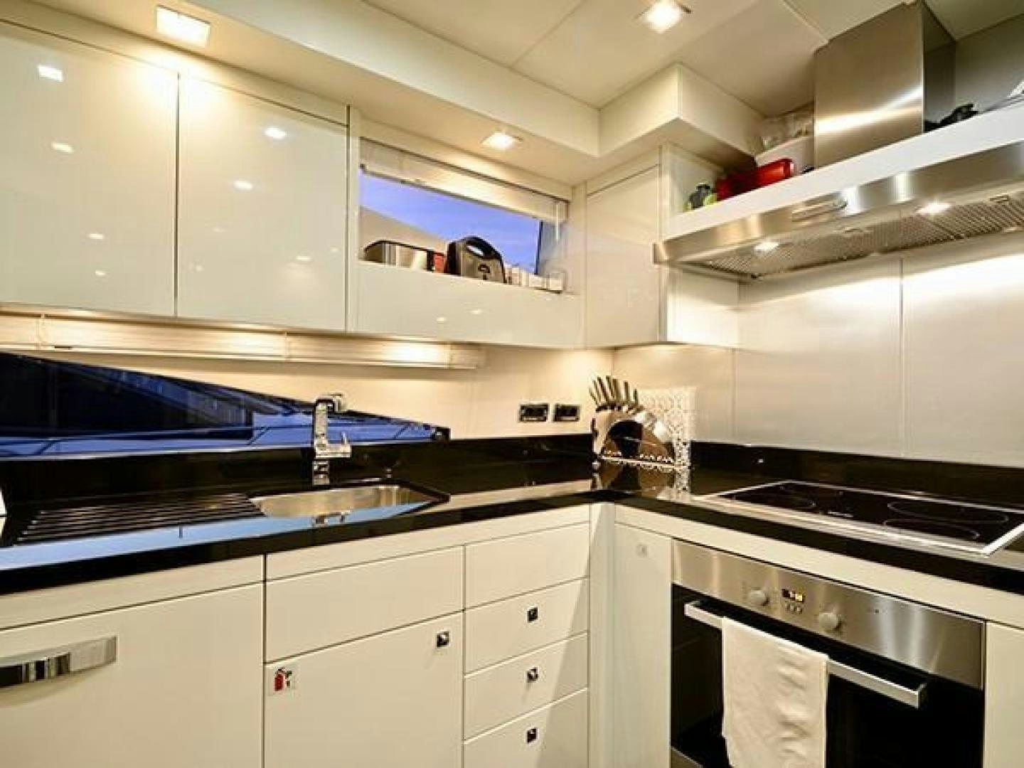 a kitchen with white cabinets aboard EXIMIUS Yacht for Sale