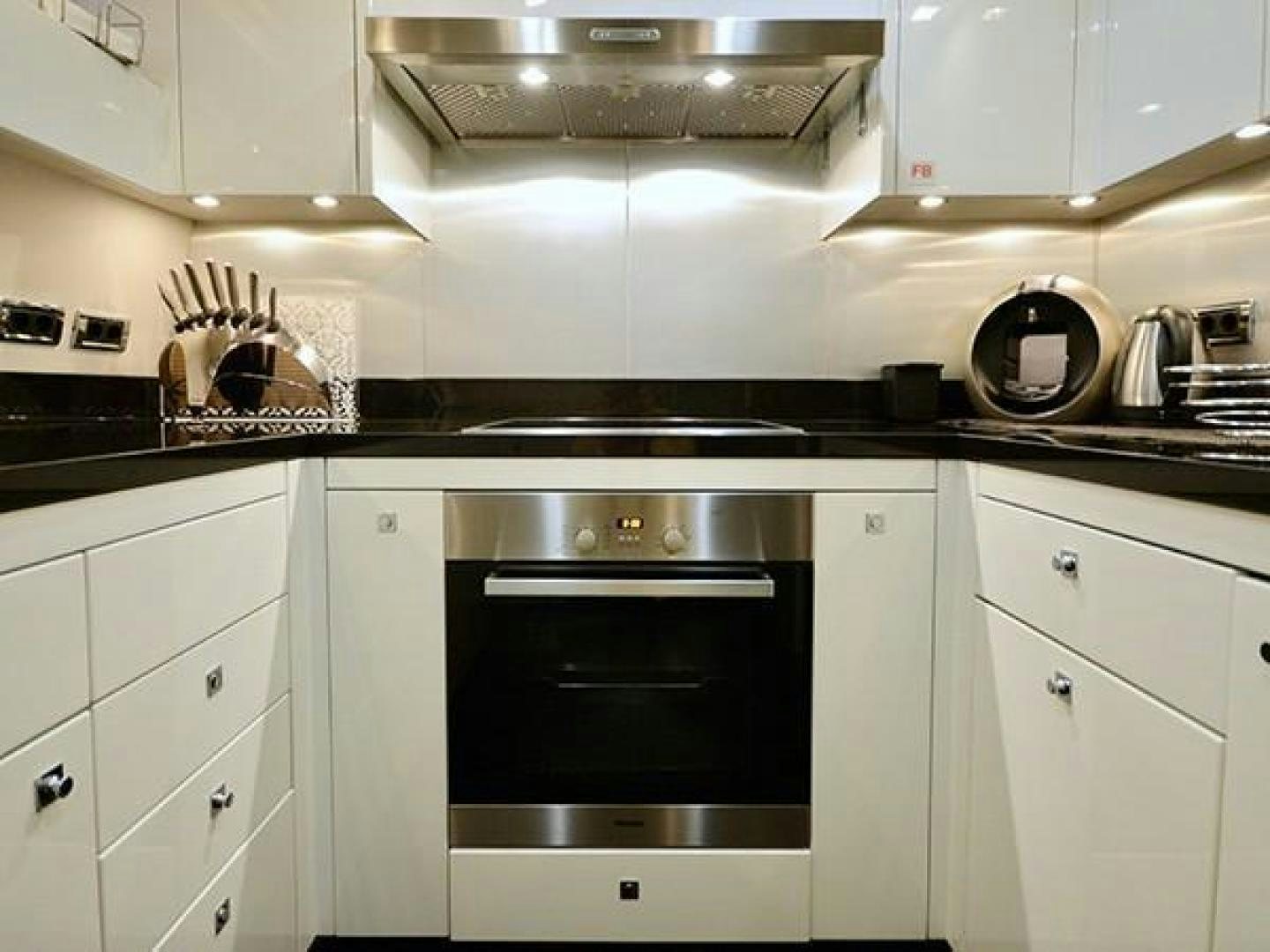 a kitchen with white cabinets aboard EXIMIUS Yacht for Sale