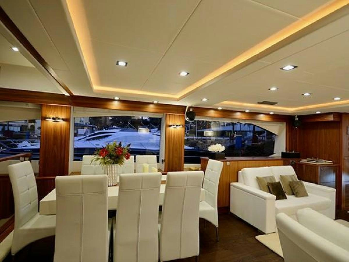 a room with white chairs and a large screen aboard EXIMIUS Yacht for Sale