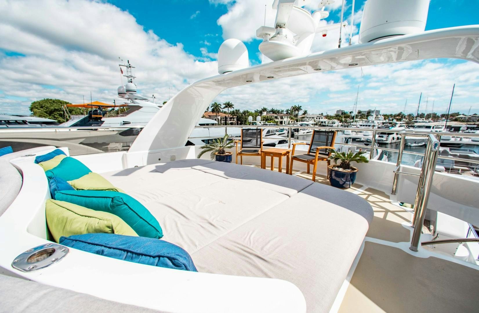 a large white tent with chairs and tables on a patio with a view of a city aboard DRIVEN Yacht for Sale