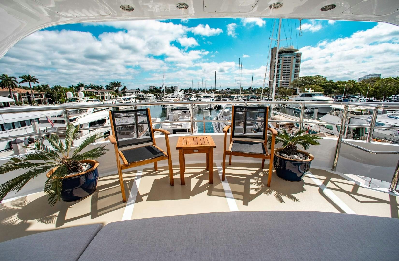 a table and chairs on a deck overlooking a marina aboard DRIVEN Yacht for Sale