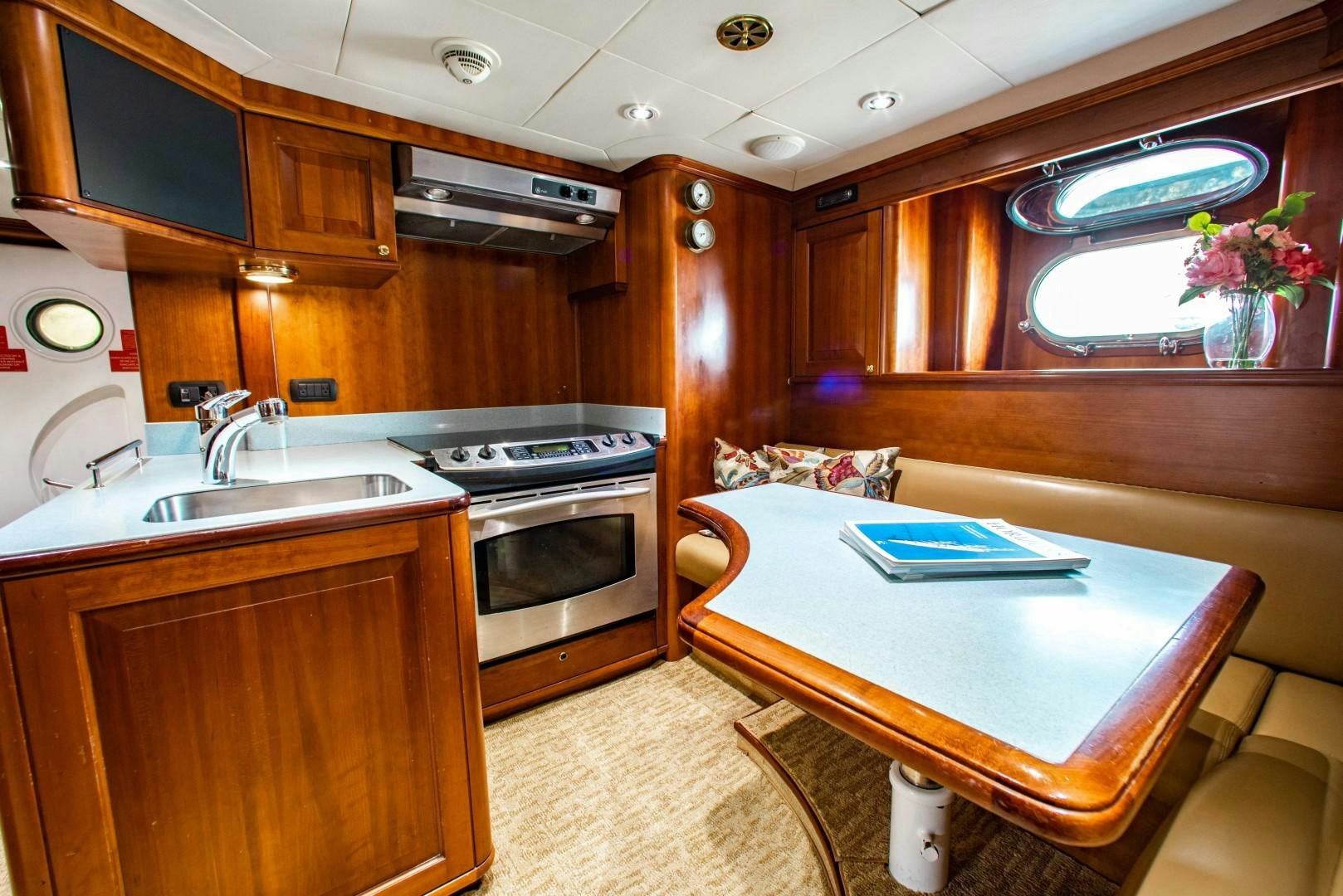 a kitchen with a table and a bed aboard DRIVEN Yacht for Sale
