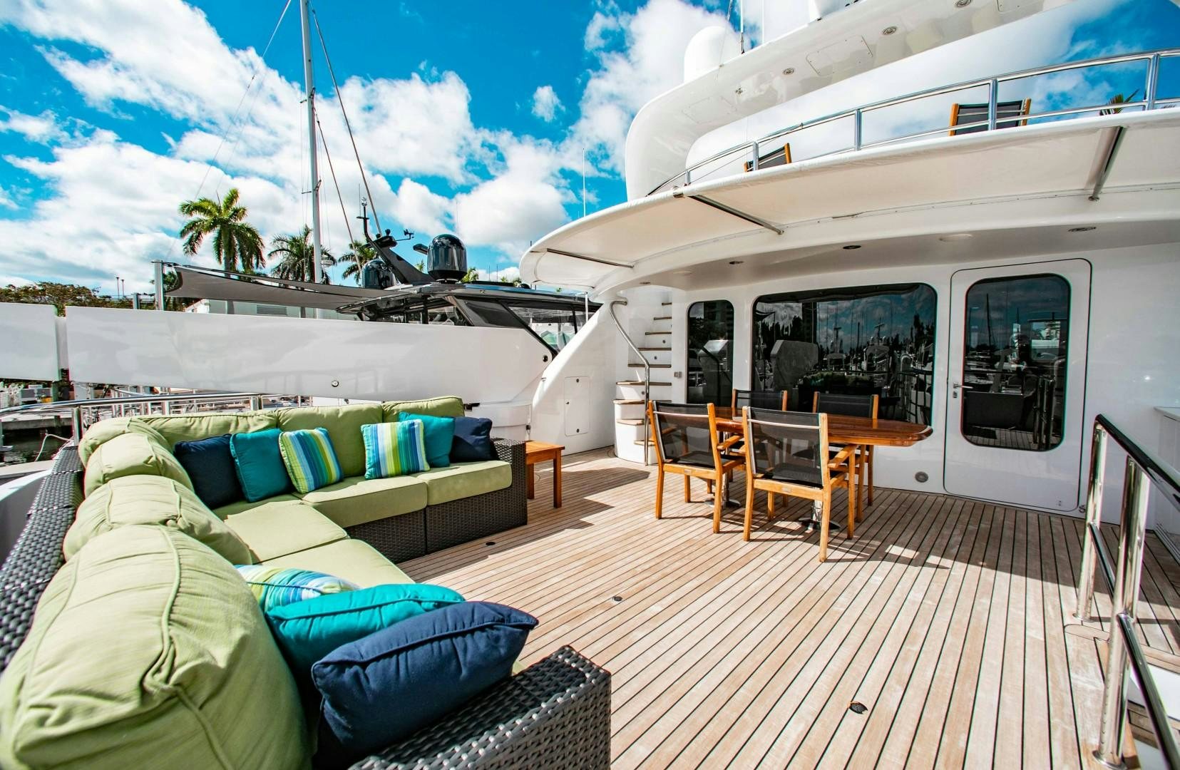 a deck with a couch and chairs on it aboard DRIVEN Yacht for Sale