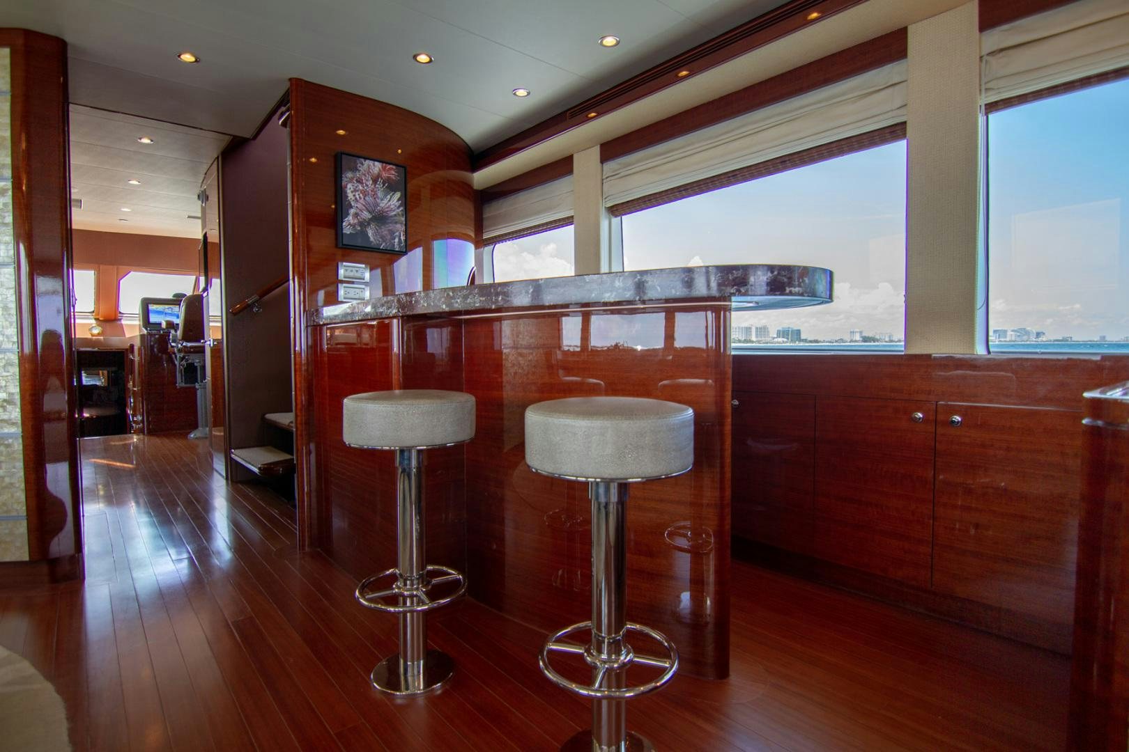 a bar with stools and stools in a room with wood cabinets aboard BRAVO Yacht for Sale