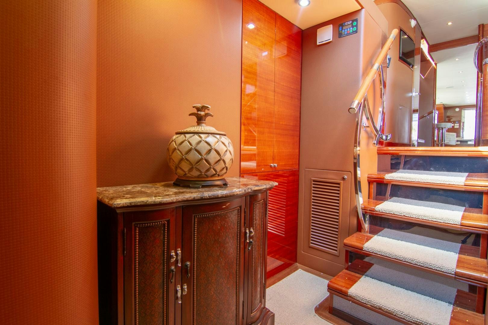 a room with a large vase on a table and a shelf with books aboard BRAVO Yacht for Sale