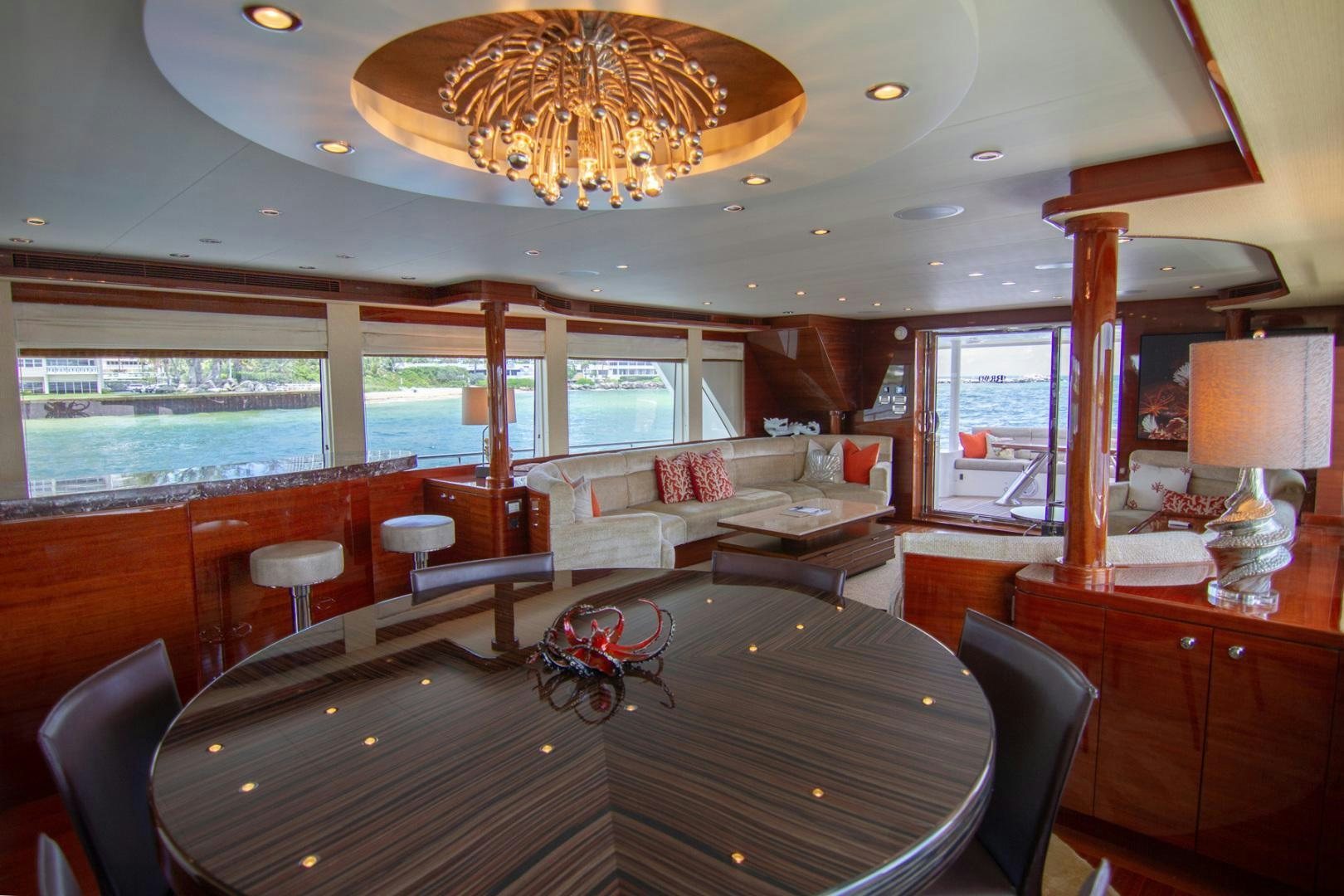 a large living room with a large chandelier aboard BRAVO Yacht for Sale