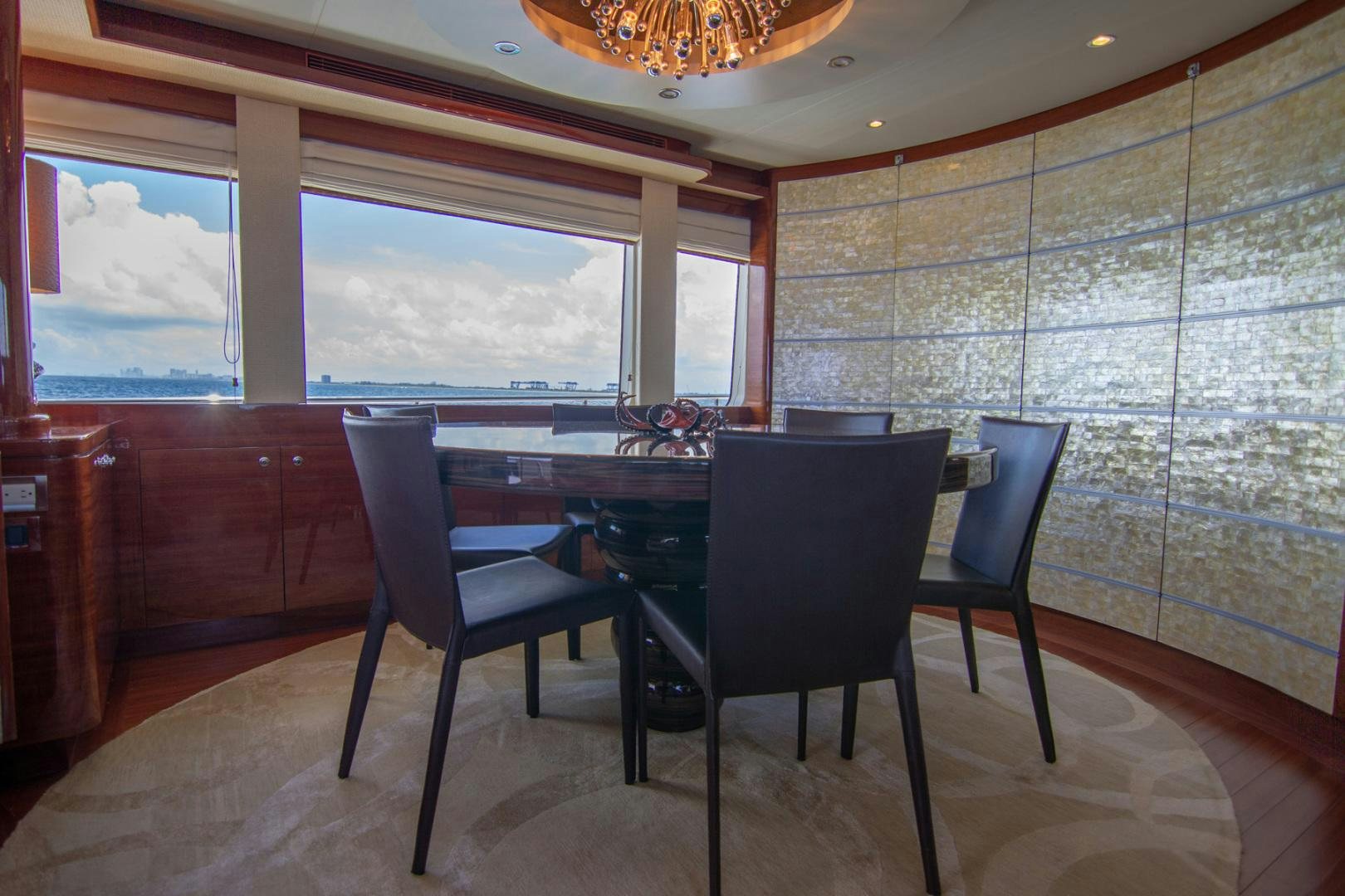 a dining table and chairs in a room with a window aboard BRAVO Yacht for Sale